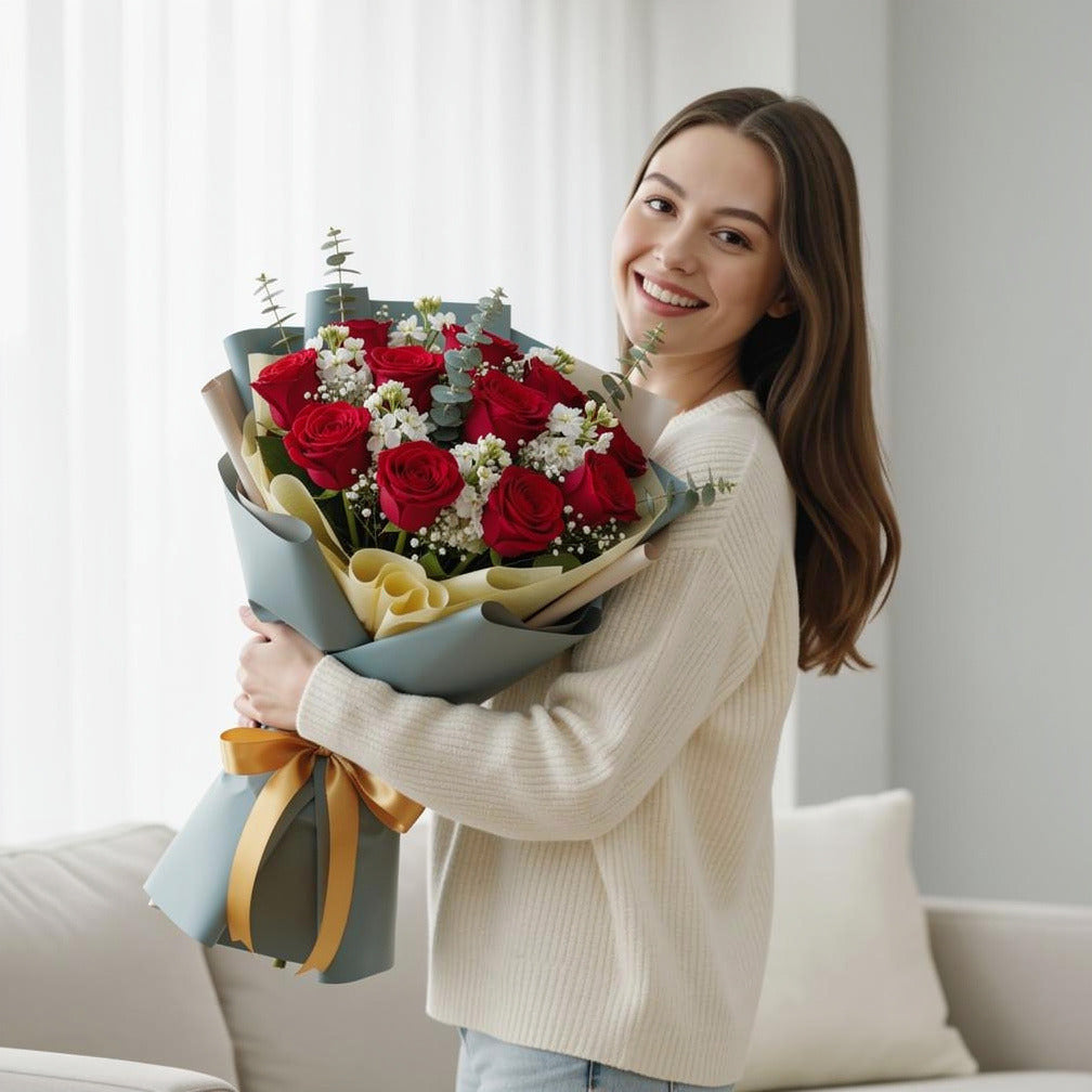 12 Red Roses & White Matthiola Bouquet for Anniversary held by a model, view 1