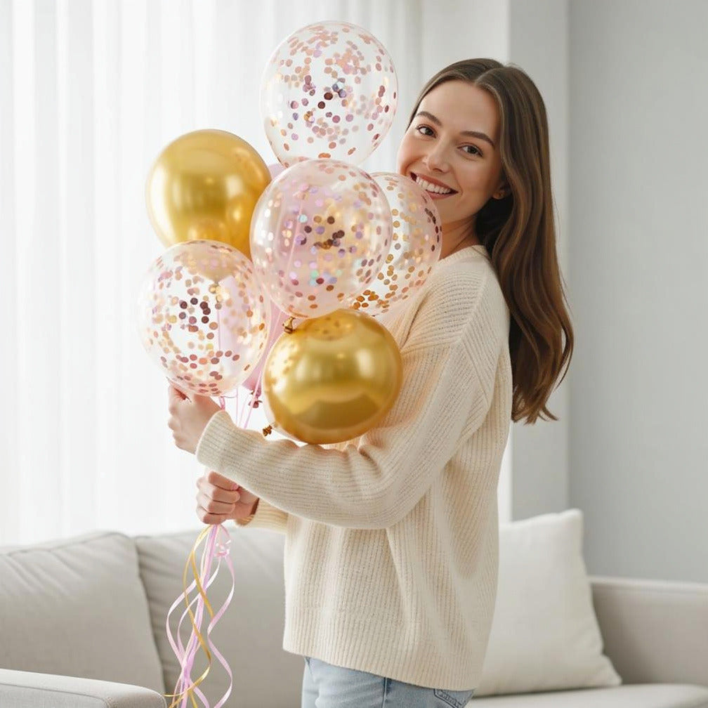 2 Golden Foil Balloons with 5 Pink Confetti Balloons held by a model, view 1