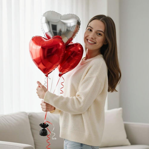 2 Red & 2 Silver Helium Heart-Shaped Foil Balloons Set held by a model, view 1