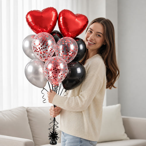 2 Red Heart, 2 Black & 2 Silver Round Helium Foil Balloons with 3 Red Confetti Balloons held by a model, view 1