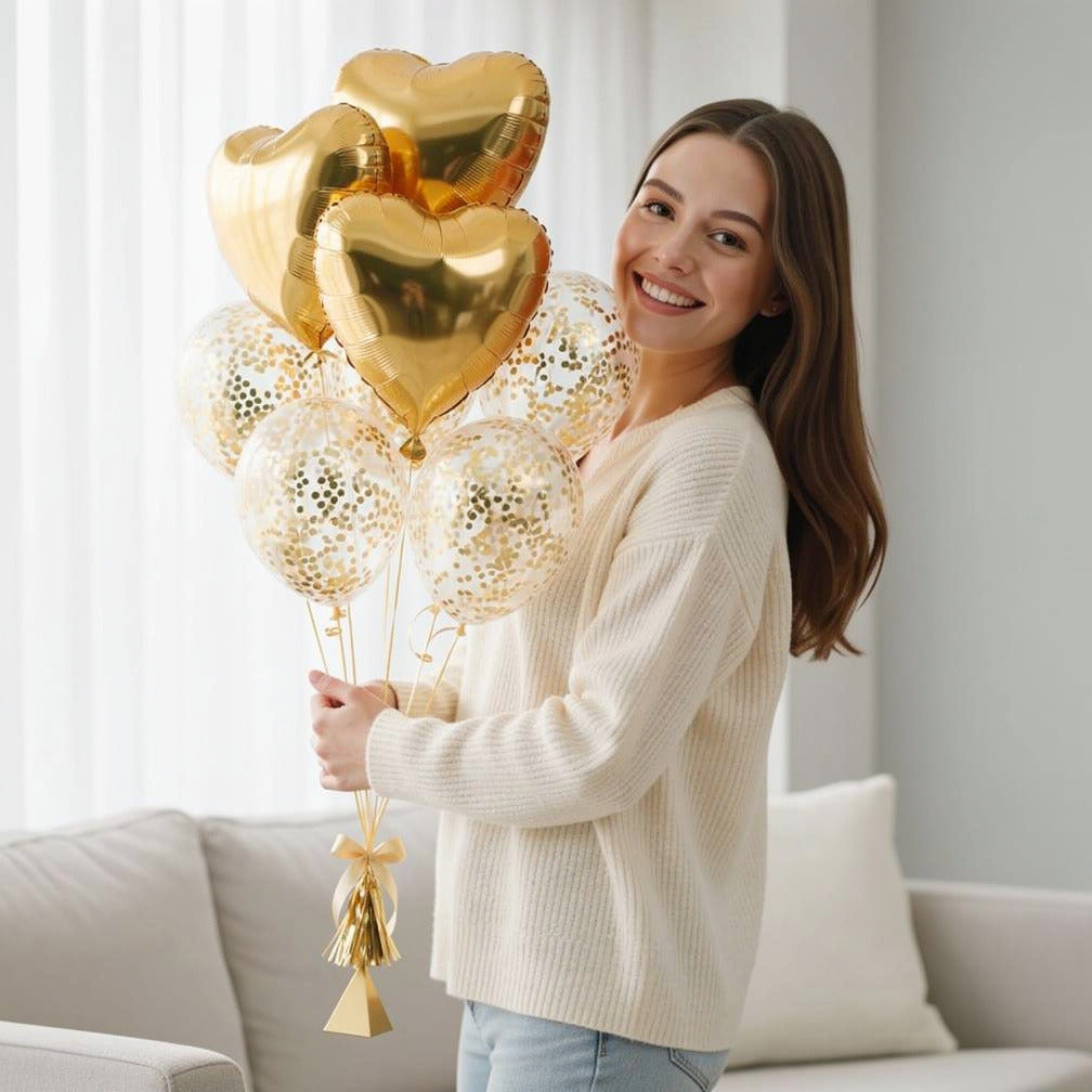 3 Golden Heart Helium Foil Balloons with 5 Confetti Balloons held by a model, view 1