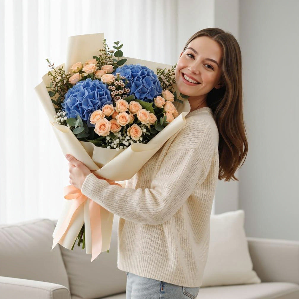 Elegant Blue Hydrangea & Peach Baby Rose Bouquet held by a model, view 1