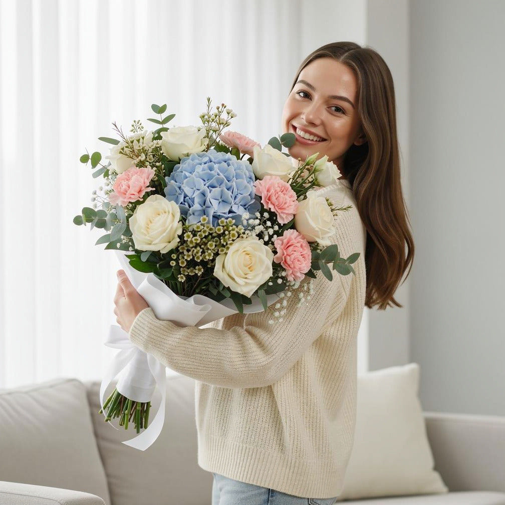 Elegant Bridal Bouquet of White Roses, Pink Carnations & Blue Hydrangea held by a model, view 1