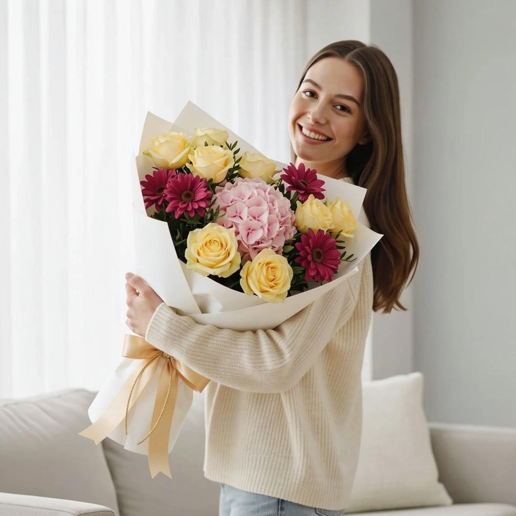 Mother’s Day Golden Glow Rose & Hydrangea Bouquet held by a model, view 1