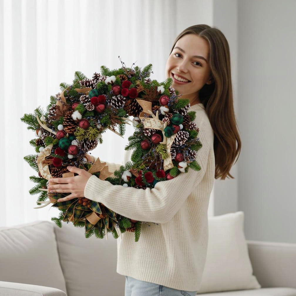 Rustic Charm Red & Green Christmas Wreath held by a model, view 1