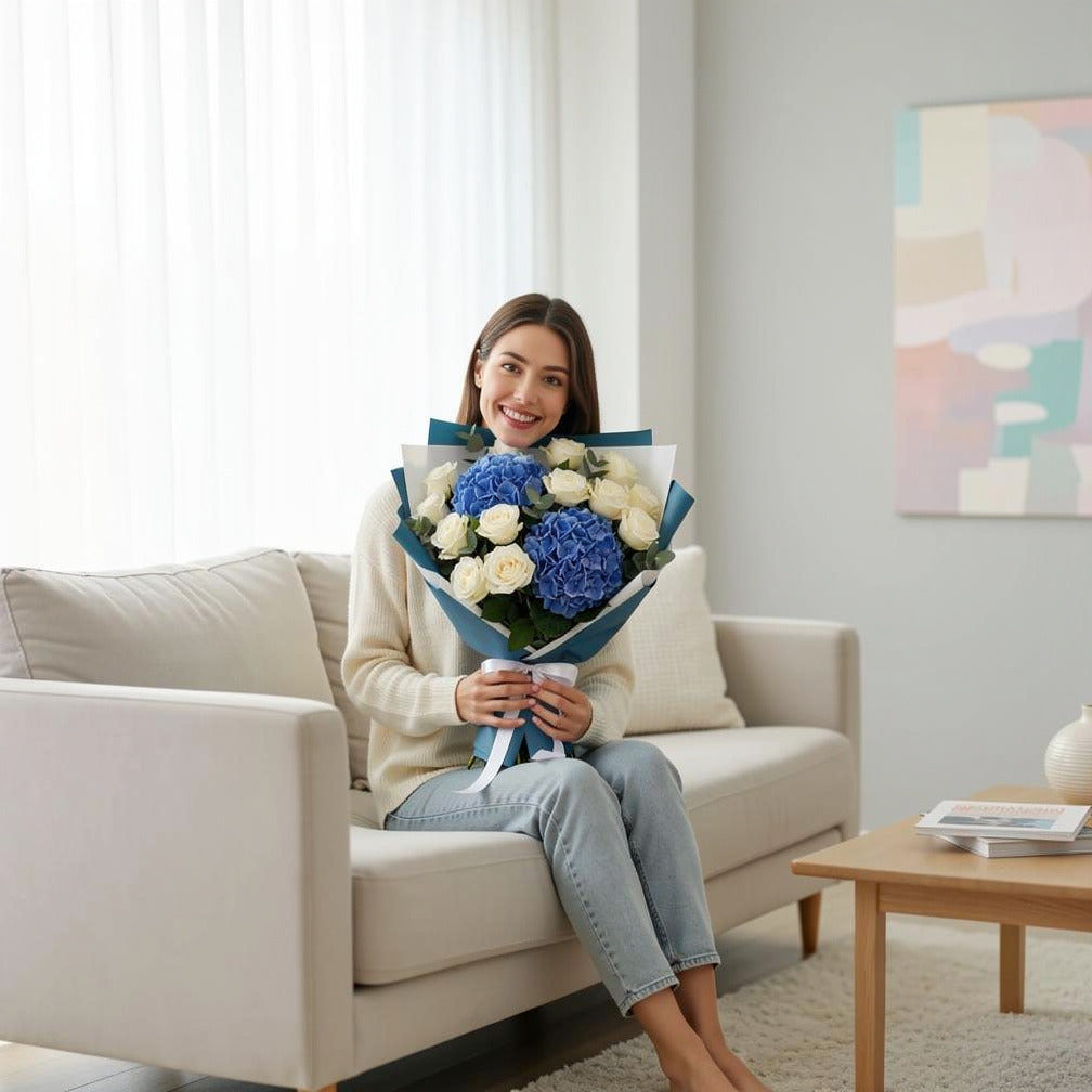 Teacher’s Day Royal Blue Hydrangea & White Rose Bouquet held by a model, view 3
