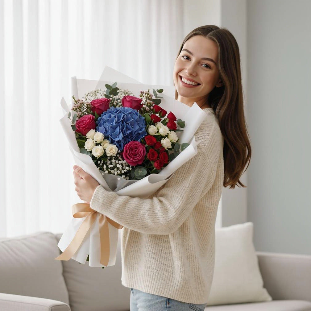 Women’s Day Blue Hydrangea & Mixed Rose Bouquet held by a model, view 1